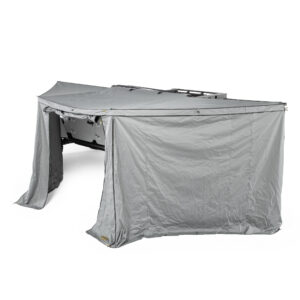 Vehicle awning with gray fabric walls fully deployed creating an enclosed outdoor shelter